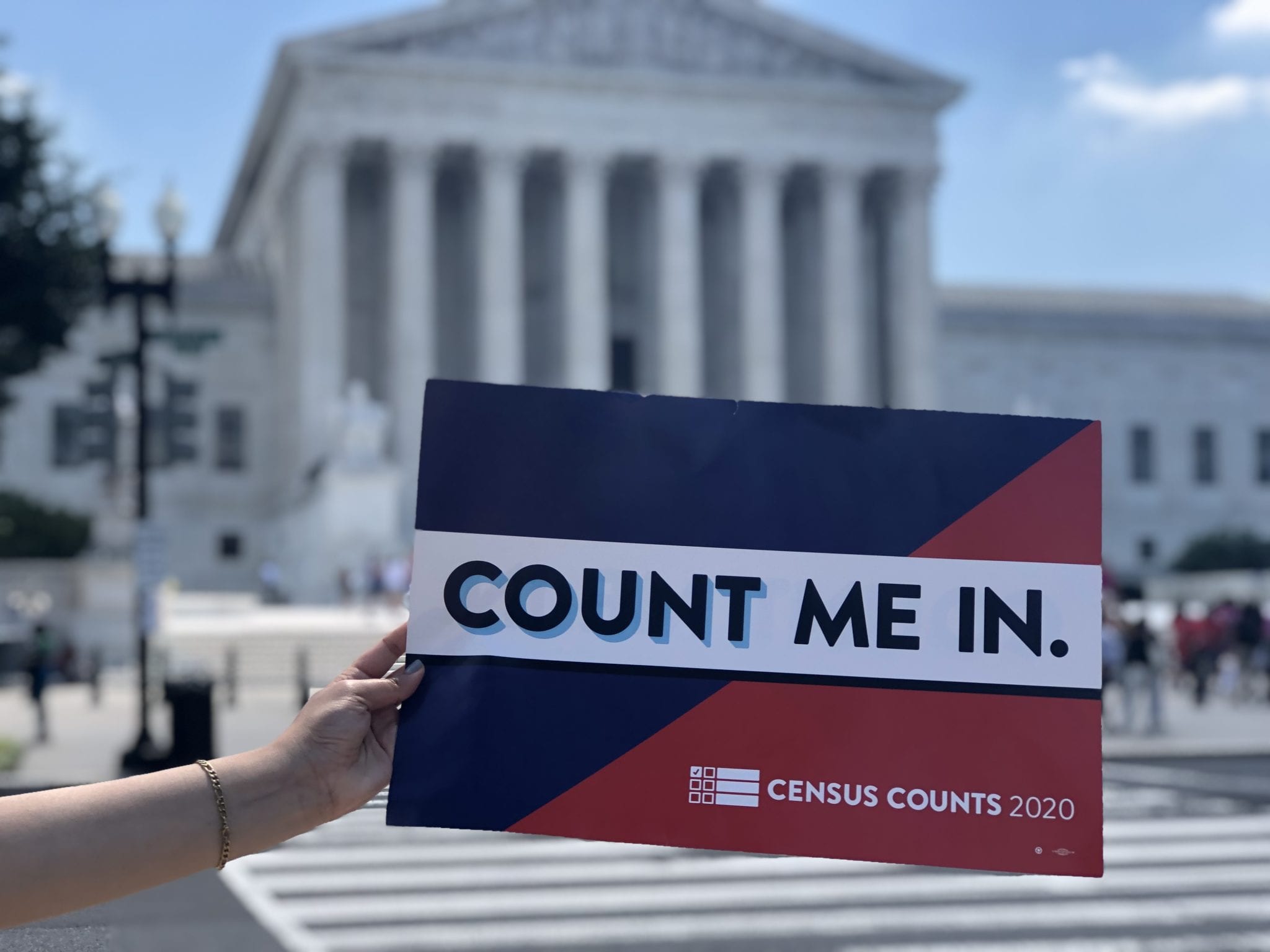 "Count me in" sign held up in front of the steps of the Supreme Court