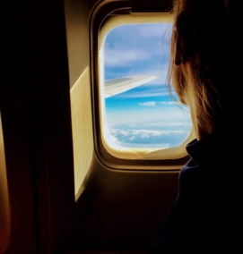 Person looks out window of airplane