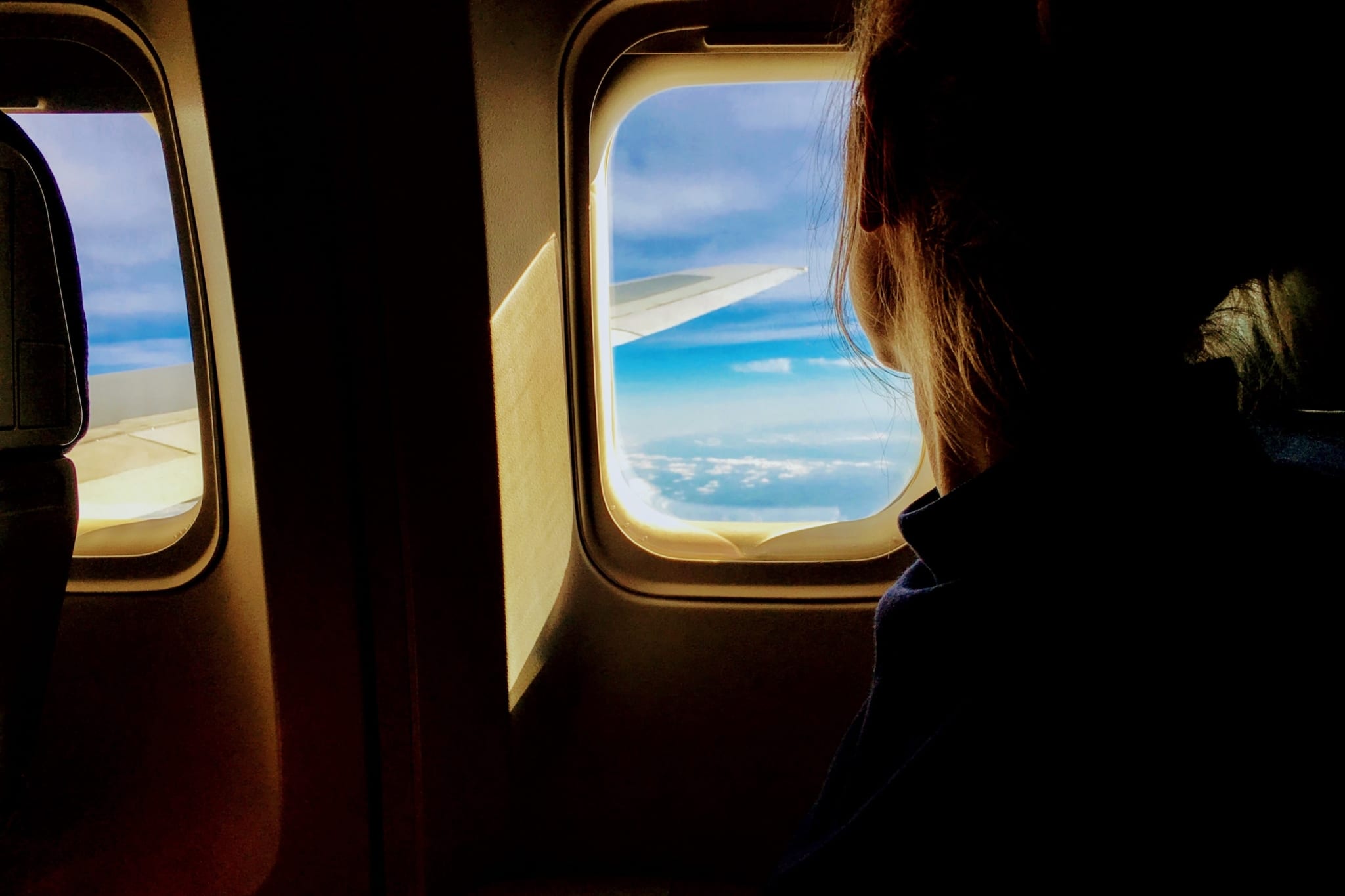 Person looks out window of airplane