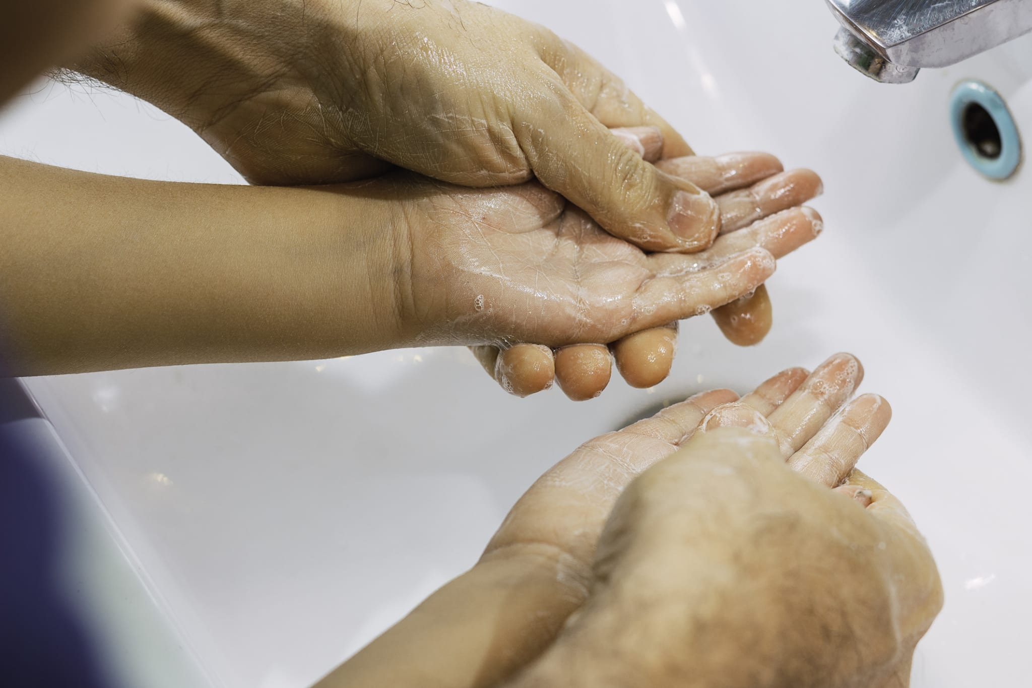 ad washing his little son's hands with soap and water stock photo