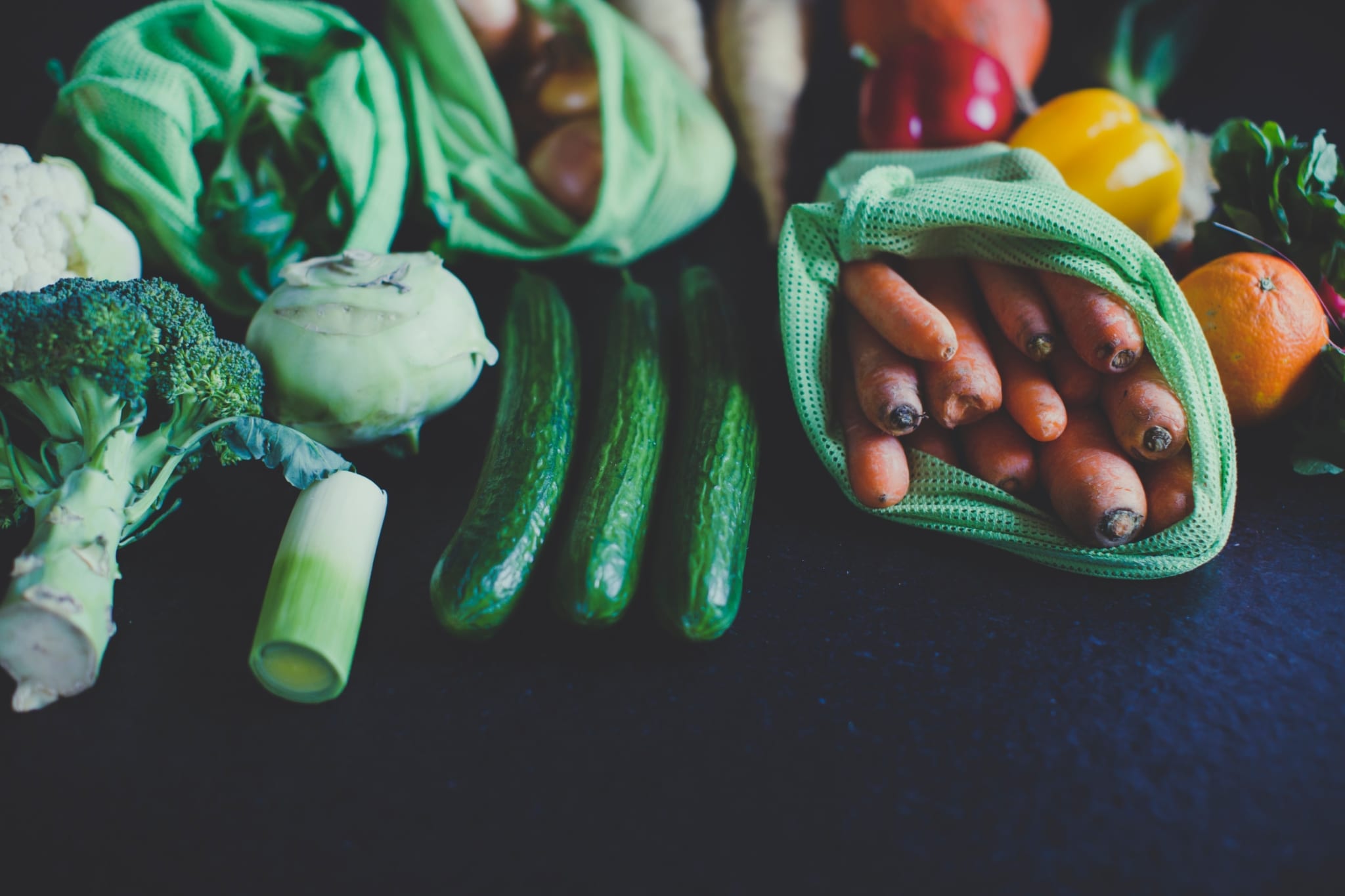 Green chili peppers and yellow bell pepper in plastic bags