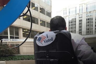 An I voted sticker on the back of a wheel chair