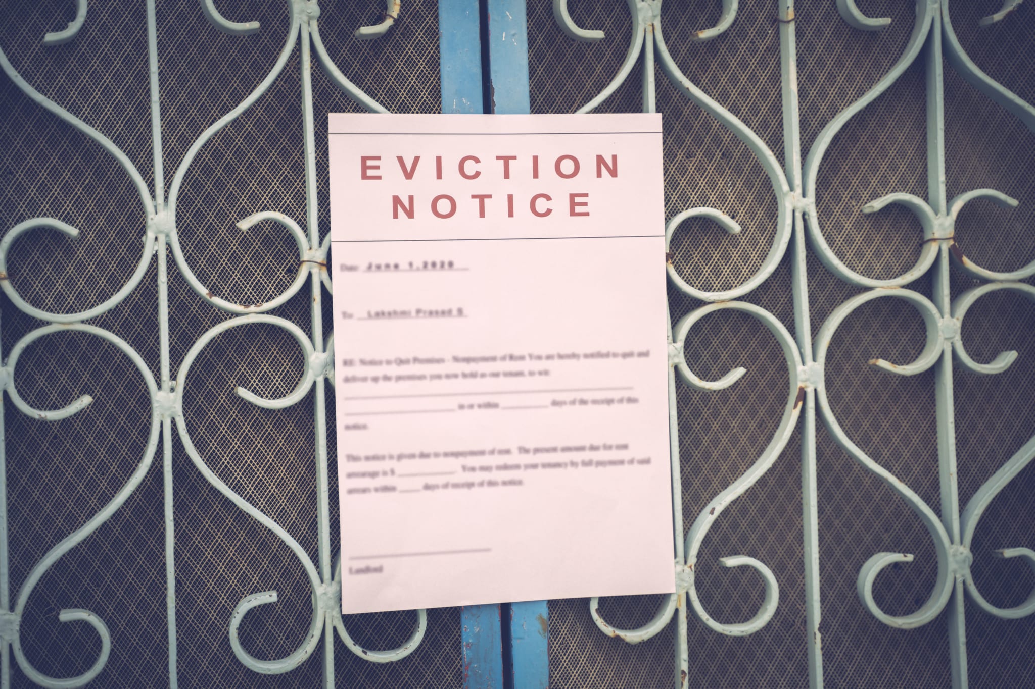 eviciton notice on a main door with blurred details of a house with vintage filter