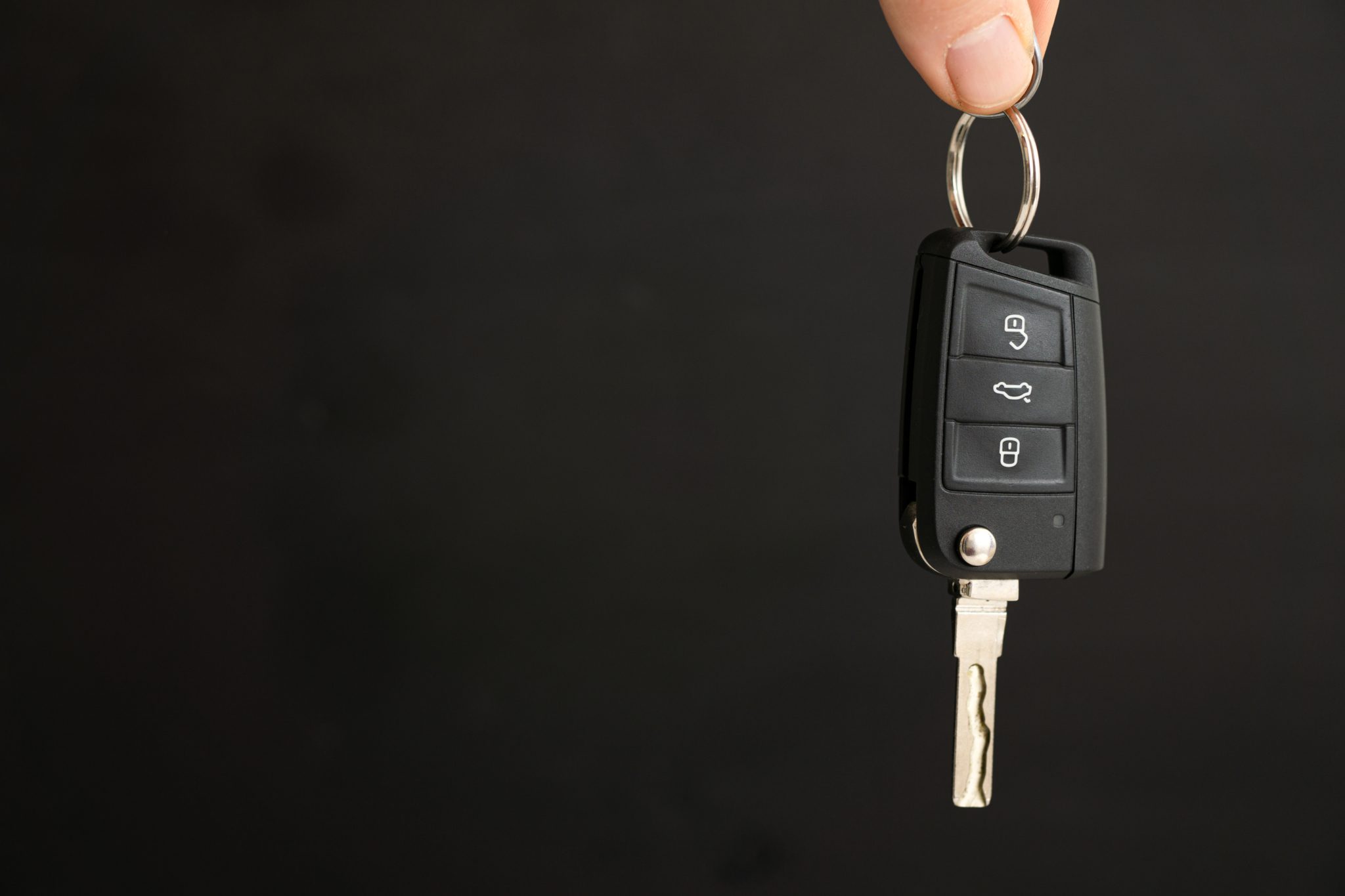 person holding key in hand and black background
