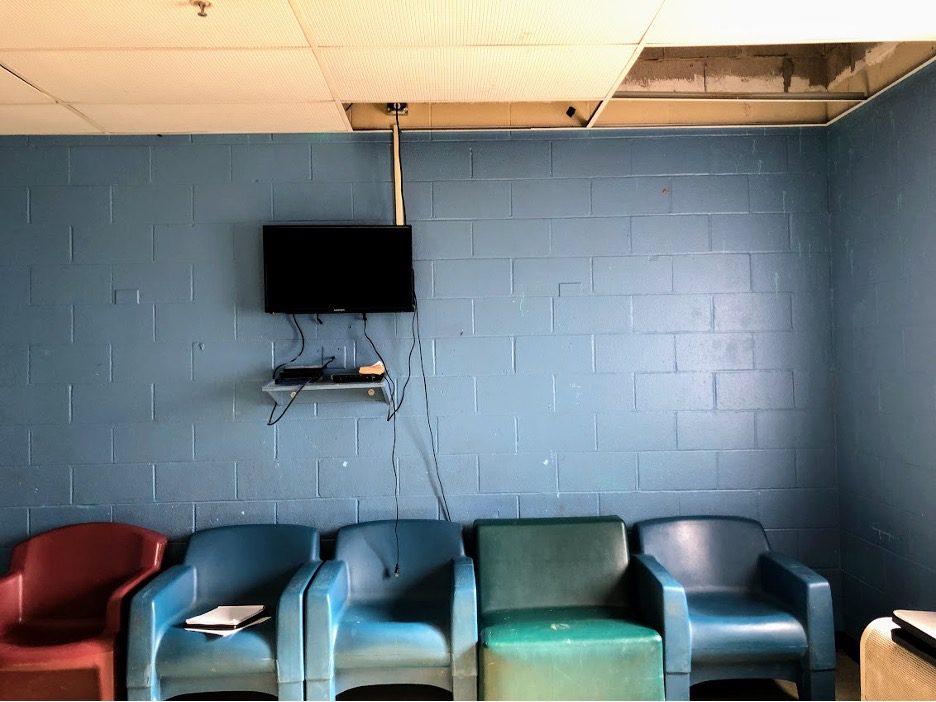 A room with brick walls with chairs and a television