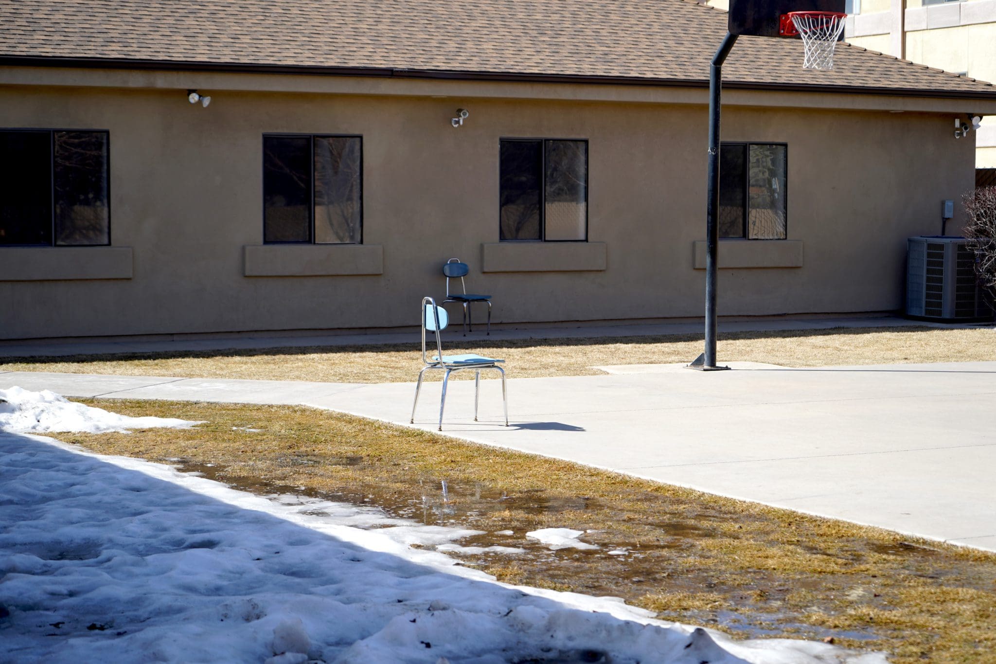 Lone chair in a basketball court area with snow