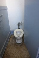 A toilet in a narrow stall.