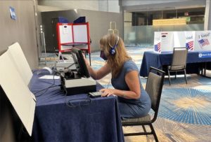 An individual testing voting equipment in the conference exhibit hall.