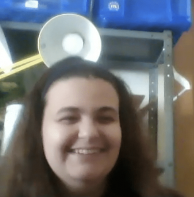 Juliet, a white woman with long brown hair, smiles for the camera